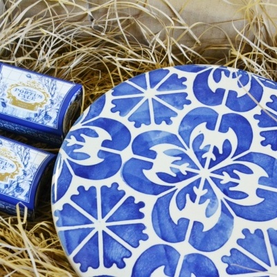 Conjunto de sabonetes embalados e caixa decorativa redonda sobre palha numa caixa de madeira