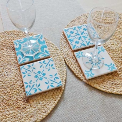 Dois jogos de azulejos azuis e brancos com taças sobre bases redondas naturais