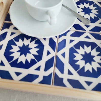 Tabuleiro de madeira com azulejos azuis e brancos, chávena e colher