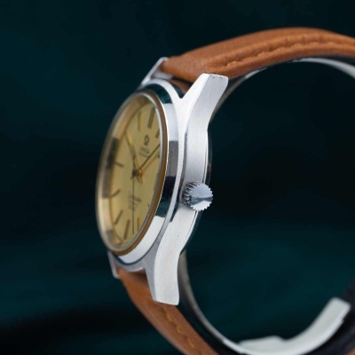 Relógio de pulso com caixa prateada e correia castanha em pele