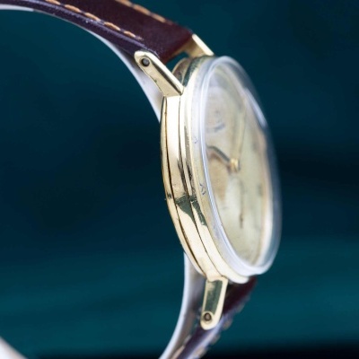 Relógio de pulso dourado com bracelete castanha