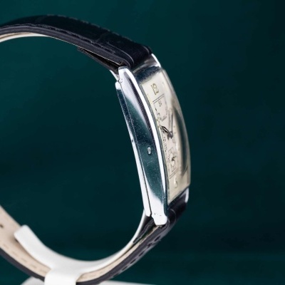 Relógio com bracelete preta em pele e mostrador retangular prateado