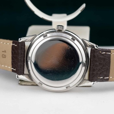 Relógio com caixa metálica prateada e bracelete em couro marrom e bege