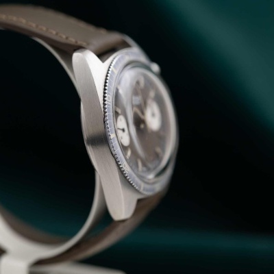 Relógio de pulso prateado com mostrador cinza e pulseira de couro castanho