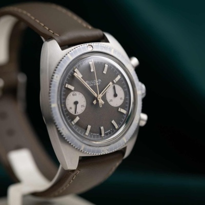 Relógio de pulso analógico com mostrador cinzento e pulseira castanha em pele sintética