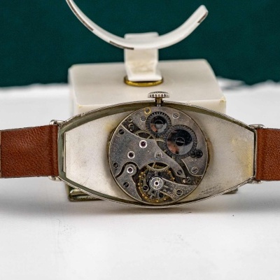 Relógio de pulso com mecanismo interno visível e bracelete de couro castanho