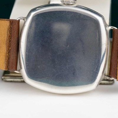 Relógio de pulso com caixa quadrada prateada e bracelete em pele castanha