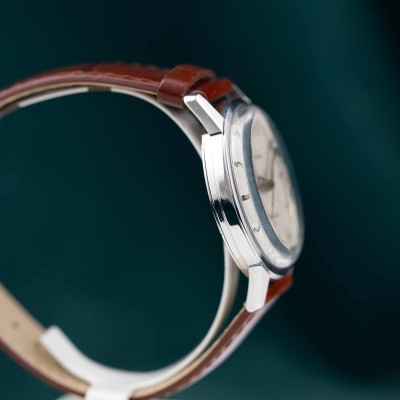 Relógio de pulso com pulseira de pele castanha e caixa metálica prateada