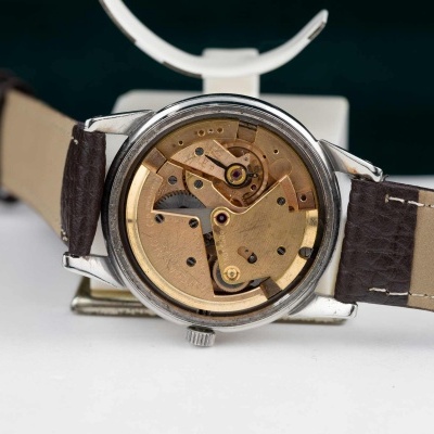 Relógio de pulso com mecanismo interno visível e bracelete castanha em pele genuína