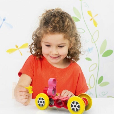 Criança a brincar com brinquedo de construção vermelho e amarelo