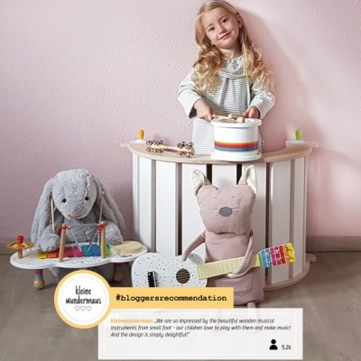 Criança a brincar com instrumentos musicais de madeira e peluches