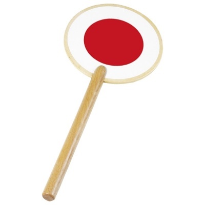 Placa circular de madeira com círculo vermelho no centro e pega de madeira