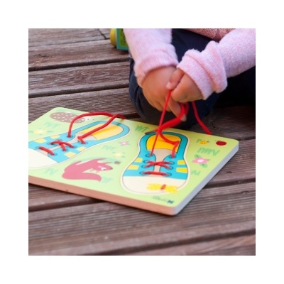 Brinquedo de madeira para aprender a atar atacadores com sapatos coloridos e cordões vermelhos