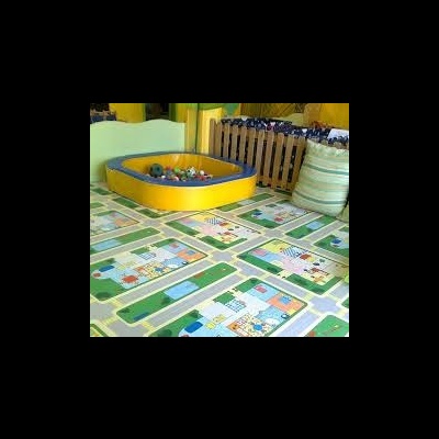 Tapete infantil com padrão de ruas e casas, piscina de bolas e cerca de madeira clara