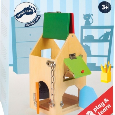 Brinquedo de madeira em forma de casa com portas coloridas numa caixa com design azul e vermelha.