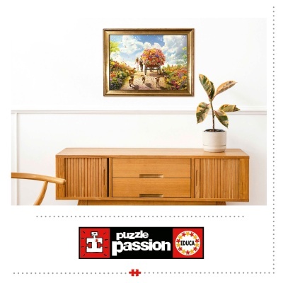 Puzzle de quadro decorativo com paisagem colorida em parede branca acima de móvel de madeira.