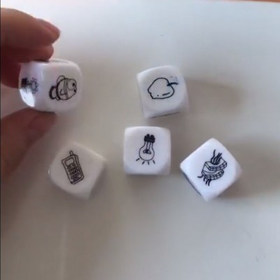 Cinco dados brancos com desenhos pretos sobre superfície branca