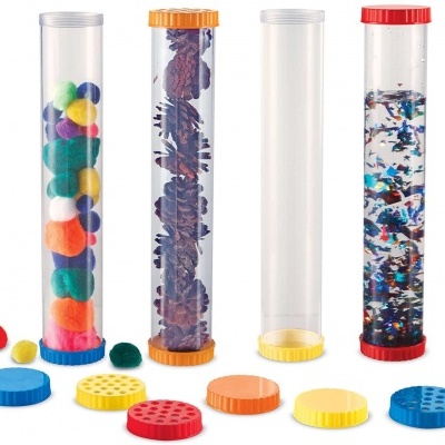 Quatro tubos transparentes com tampas coloridas contendo diferentes materiais coloridos