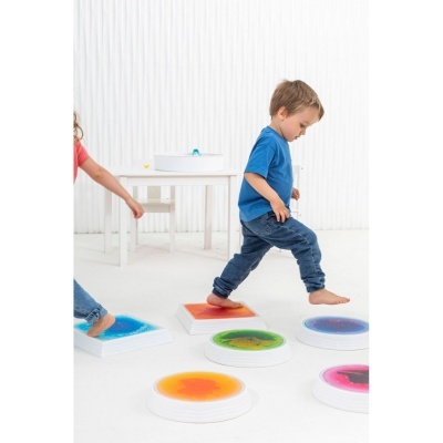 Criança a brincar com placas sensoriais coloridas