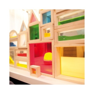 Blocos de madeira coloridos translúcidos arranjados em forma de casas.