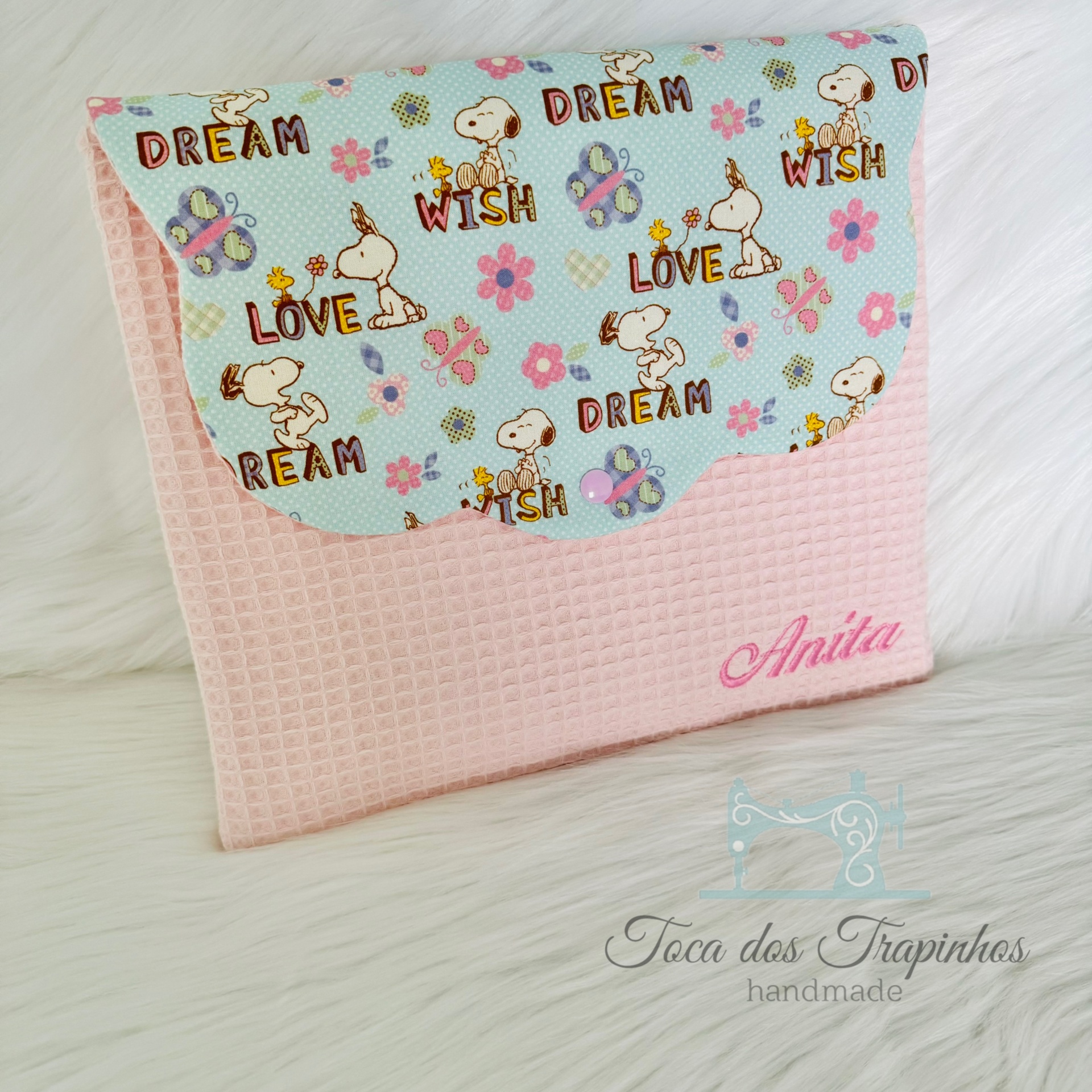 Bolsa rosa e azul com padrão Snoopy, flores e palavras, com nome Anita bordado