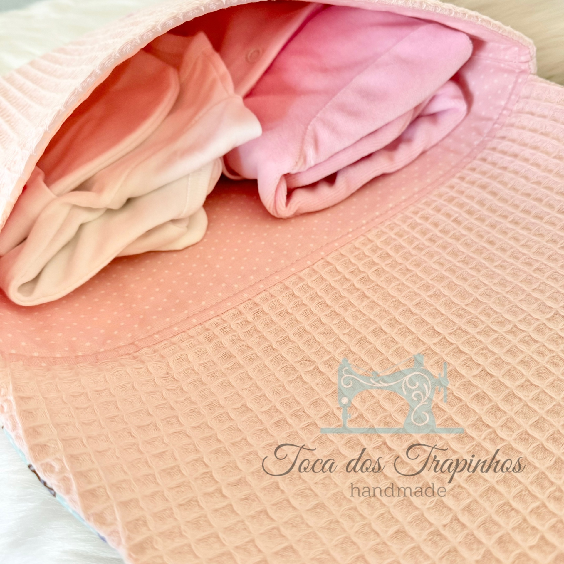 manta rosa acolchoada com tecidos enrolados e logo Toca dos Trapinhos handmade