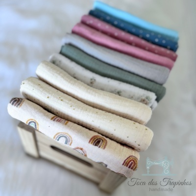 Caixa de madeira com panos de tecido coloridos e estampados variados