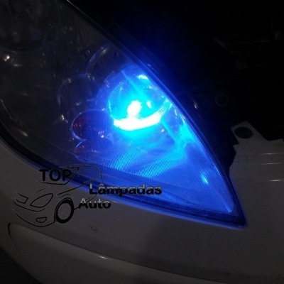Farol de carro com luz azul brilhante e logo TOP Lâmpadas Auto no capô