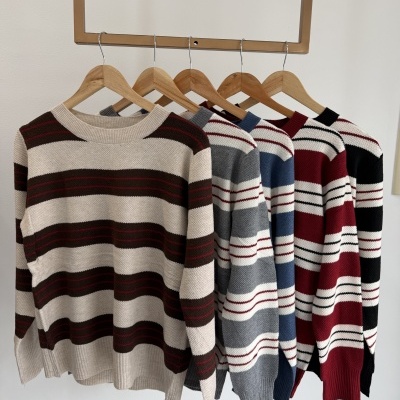 Cinco camisolas de malha com riscas horizontais em várias cores penduradas em cabides de madeira.