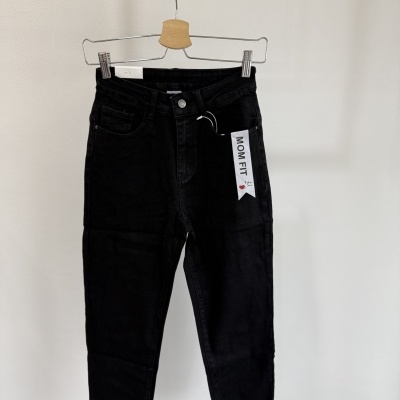 Calças mom fit pretas com etiqueta MOM FIT penduradas num cabide