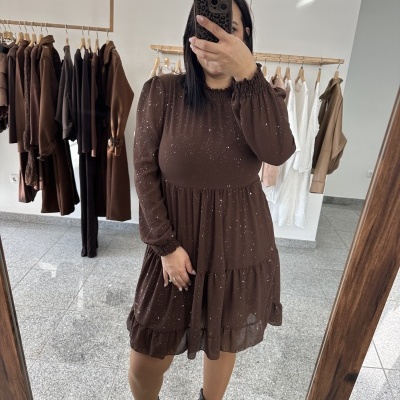 Vestido castanho com manchas brancas e mangas longas em loja de roupa