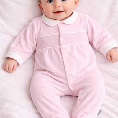 Bebé deitado com fato de veludo rosa e faixa de cabelo