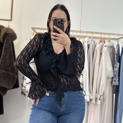 Blusa preta de renda com babados e jeans azul