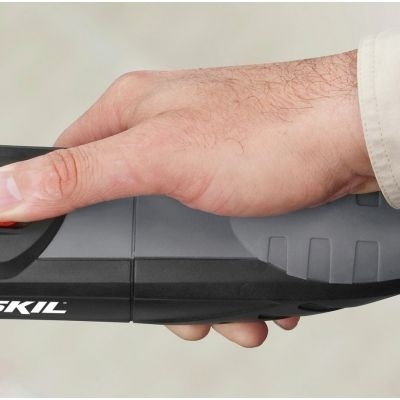 mão segurando ferramenta elétrica SKIL preta e cinzenta com botão vermelho