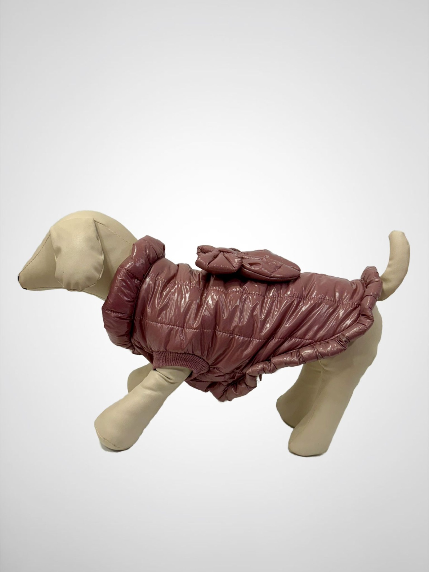 Casaco castanho brilhante para cão mostrado em manequim de tecido bege