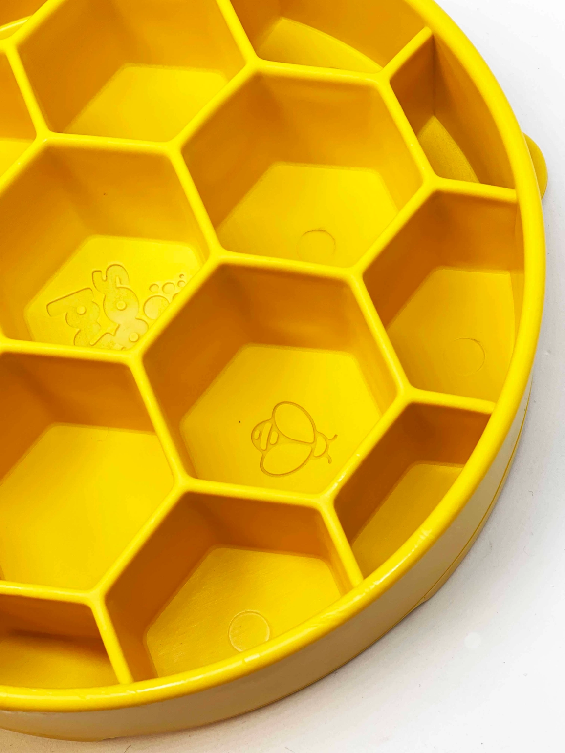 Prato amarelo de silicone com divisórias hexagonais e desenhos de abelhas