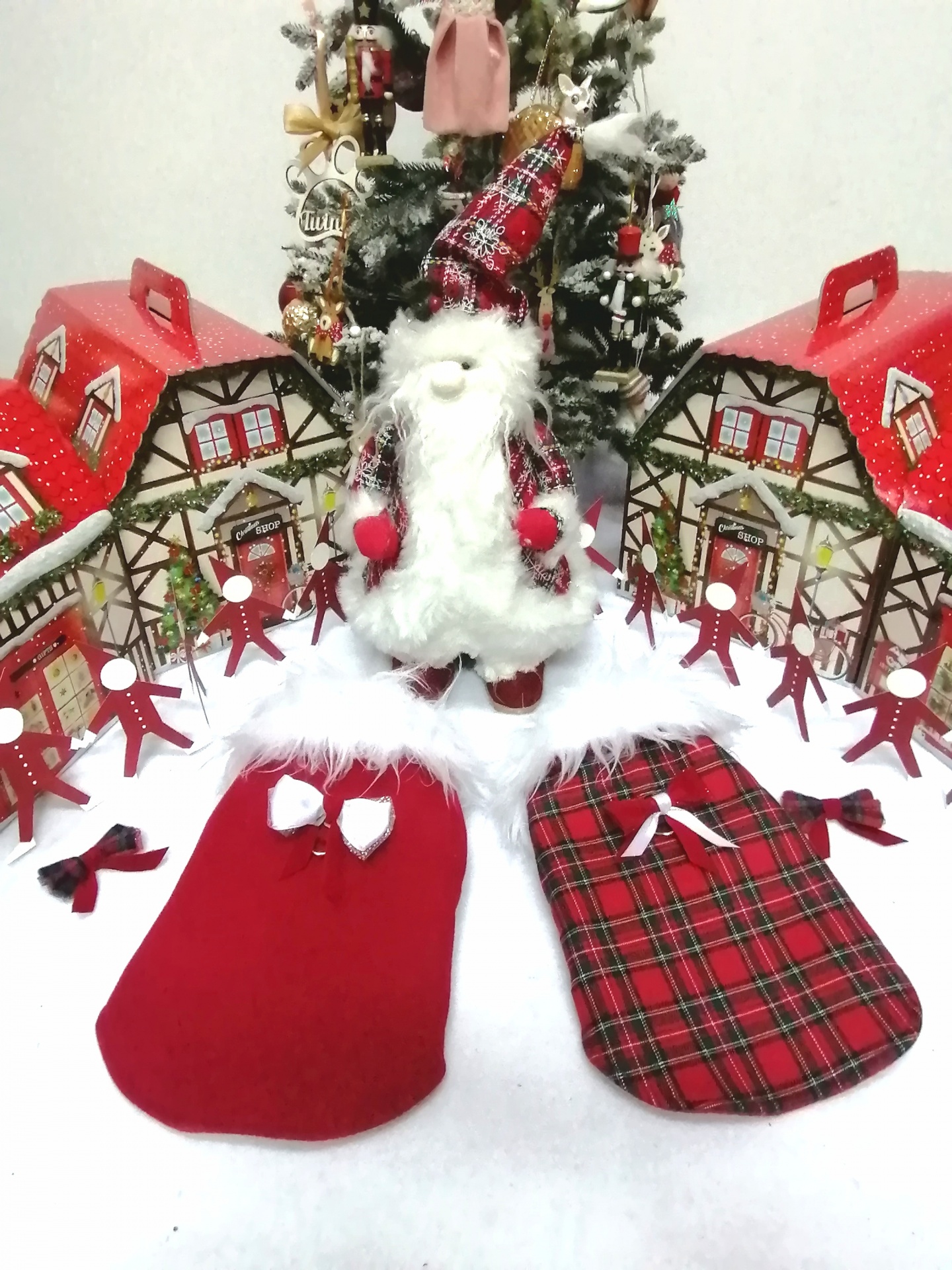 Decoração natalícia com Pai Natal e capas vermelhas para animais junto a mini casinhas e árvore de Natal