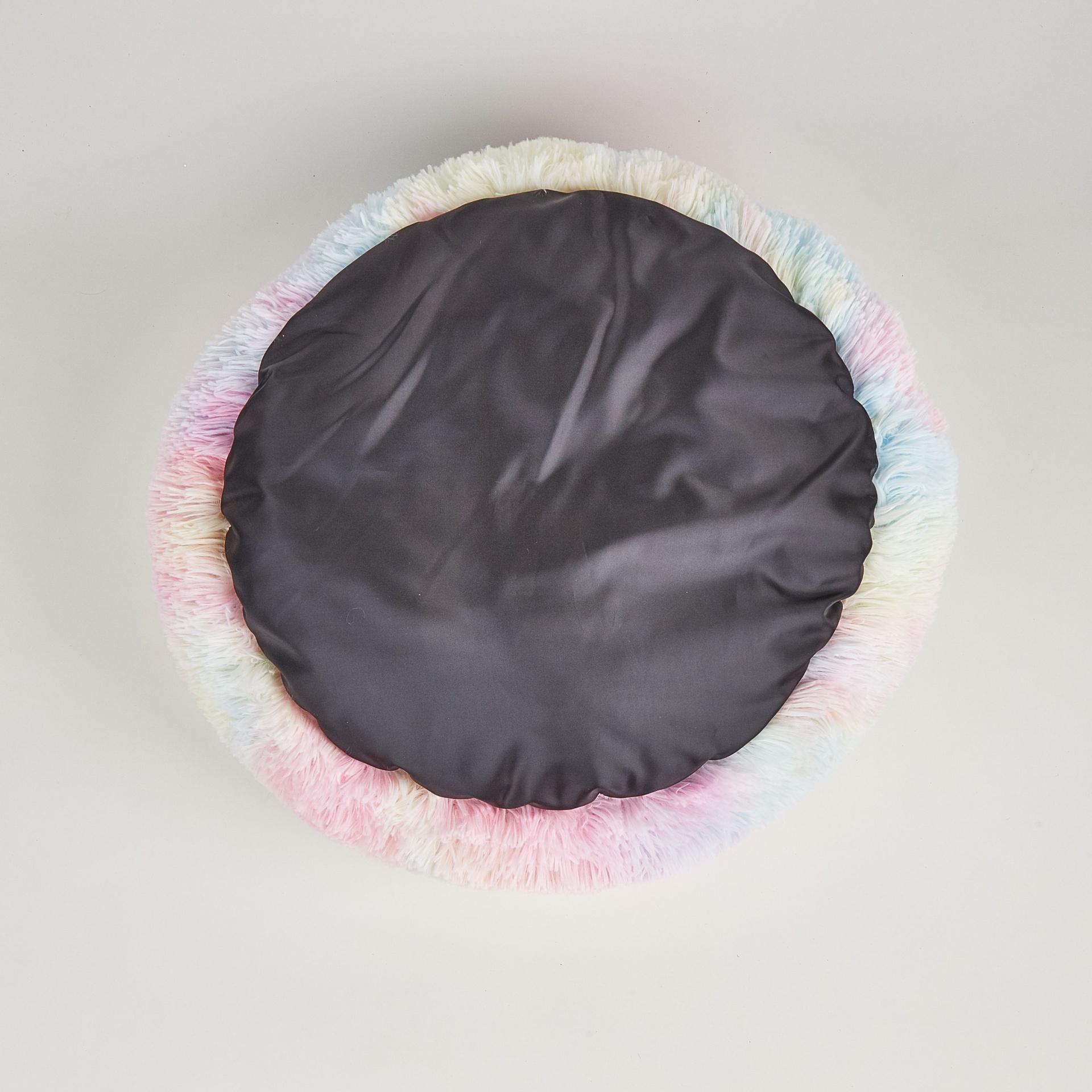 Almofada redonda com frente preta e verso felpudo colorido