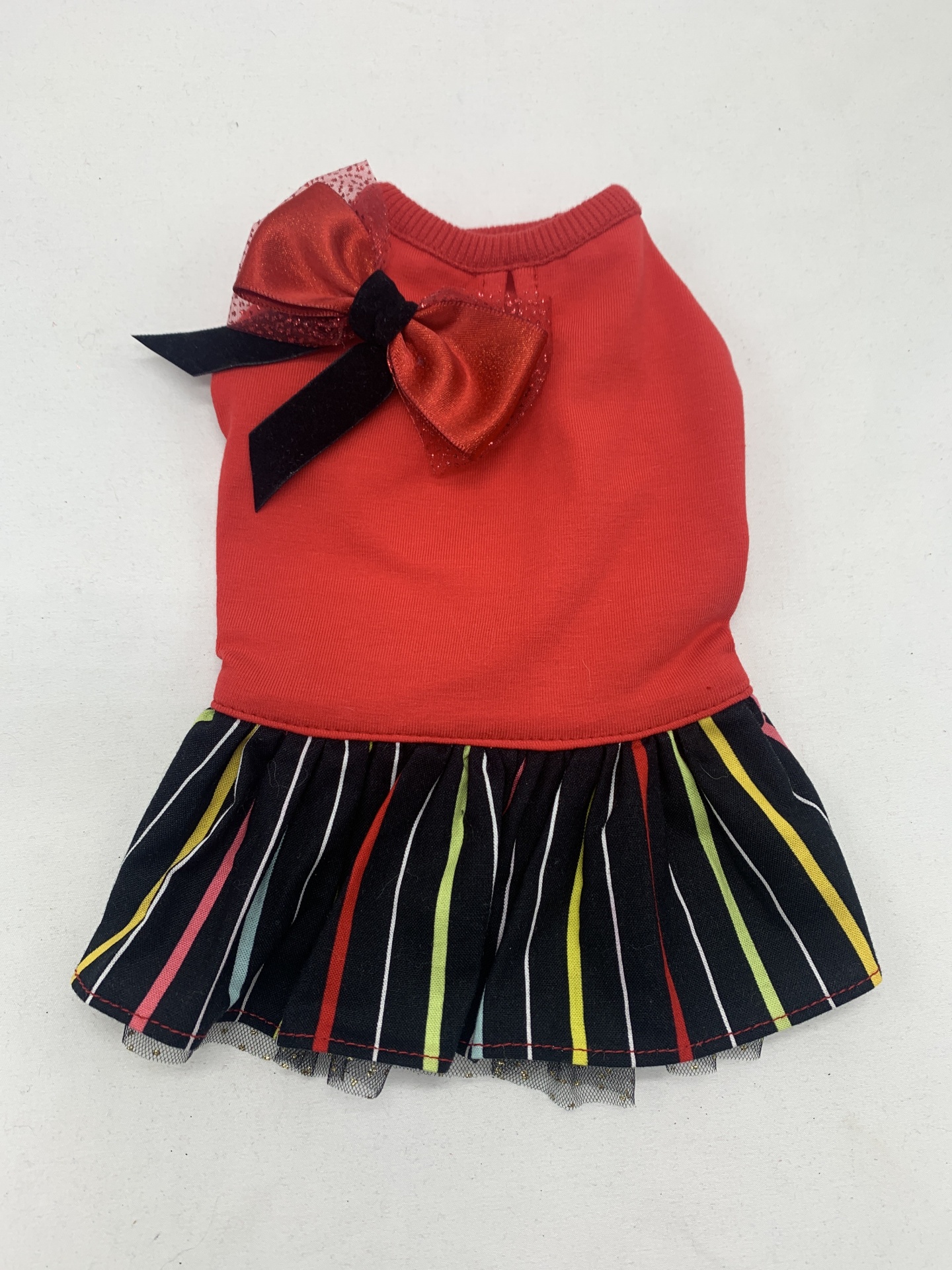 Vestido para animal de tecido vermelho com saia riscada multicolorida e laço no ombro