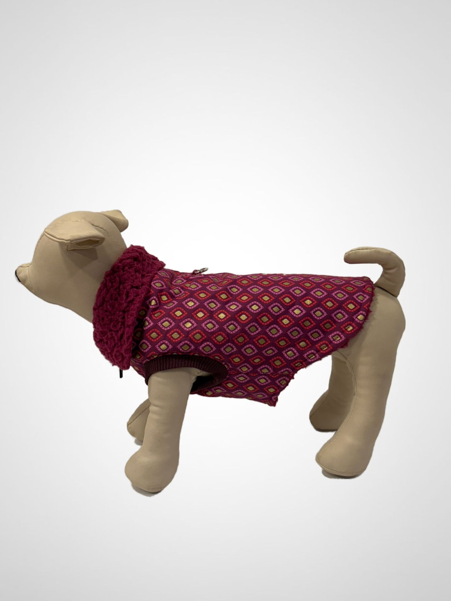 Casaco para cão vermelho com padrão geométrico e gola em malha em manequim de cachorro