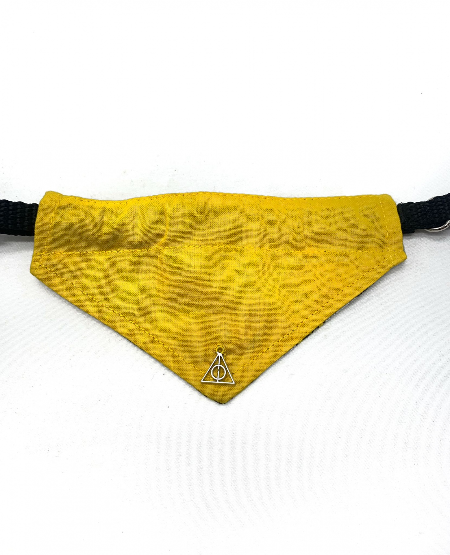 Bandana amarela com adereço metálico triangular numa fita preta ajustável