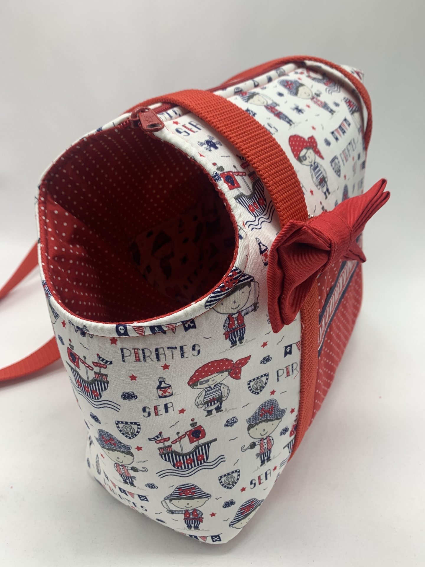Mala infantil de tecido com padrão de piratas e decoração vermelha
