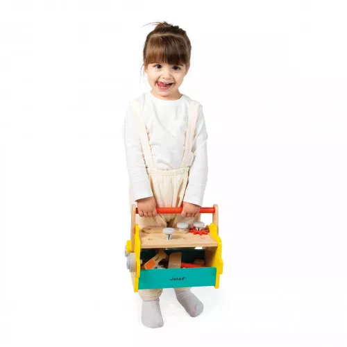 Menina segurando caixa de ferramentas de madeira colorida com ferramentas de brinquedo.