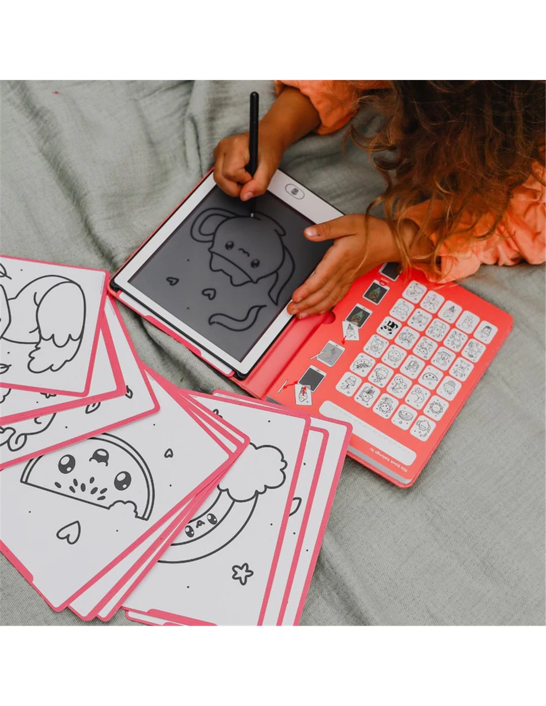 Tablet digital com capa rosa e folhas de desenho com molduras rosas ao lado