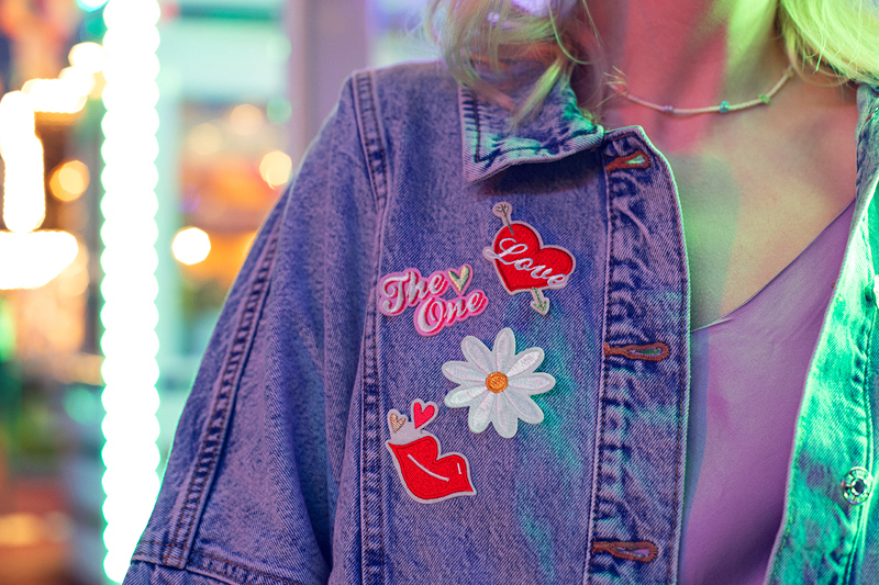 Casaco de ganga azul com patches coloridos no peito