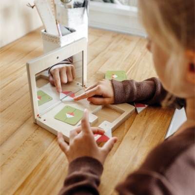 Criança a brincar com brinquedo de madeira com espelho e peças coloridas