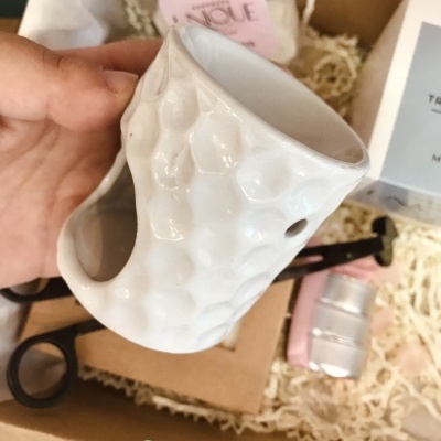 Vela de cerâmica branca texturizada com padrão de bolhas e abertura lateral