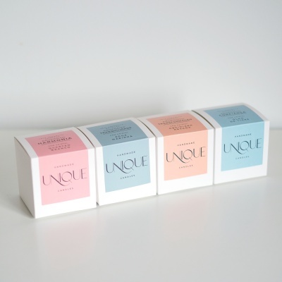 Caixas de velas artesanais Unique Candle com etiquetas rosa e azul.