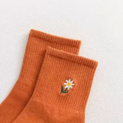 Meias laranja com bordado de margarida branca