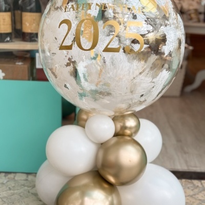 Balão transparente com texto dourado e base de balões brancos e dourados